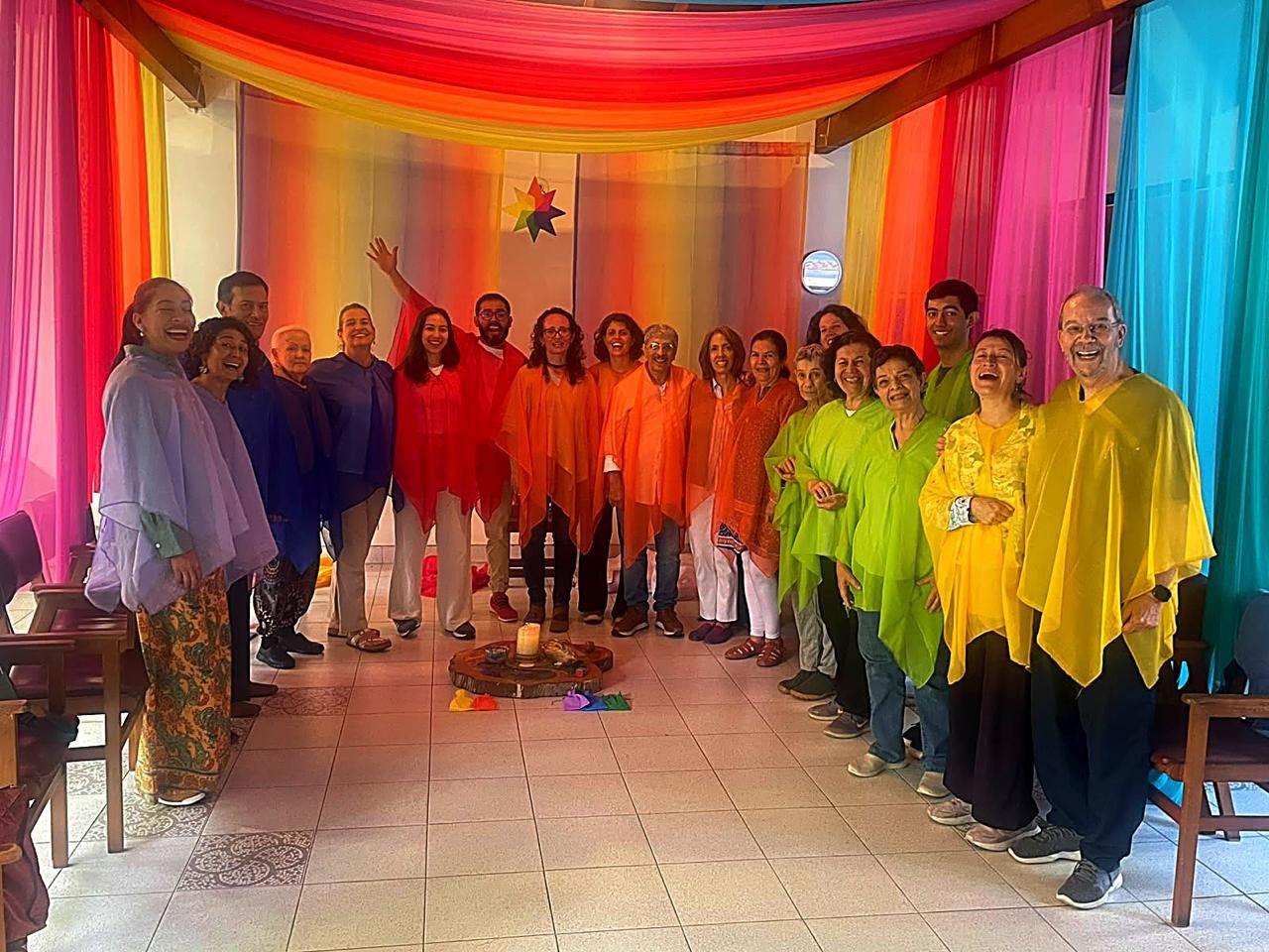 Un grupo de adultos con velos de colores, sonriendo al final de un Círculo de Adultos de Familias de Colores