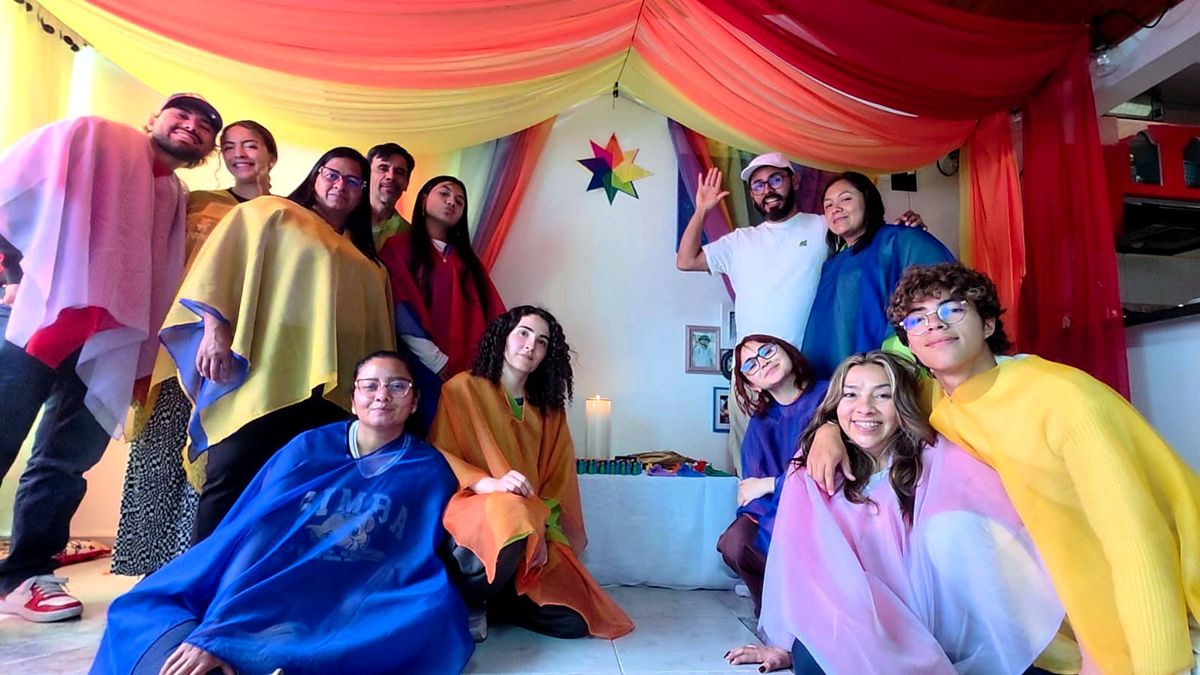 A group of young adults in colored veils at the end of a Familias de Colores circle