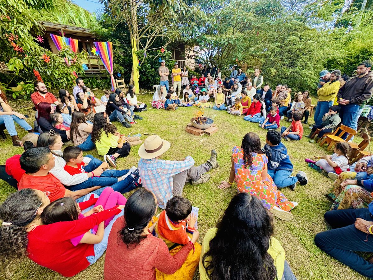 The circle of families sitting on the farm's grass