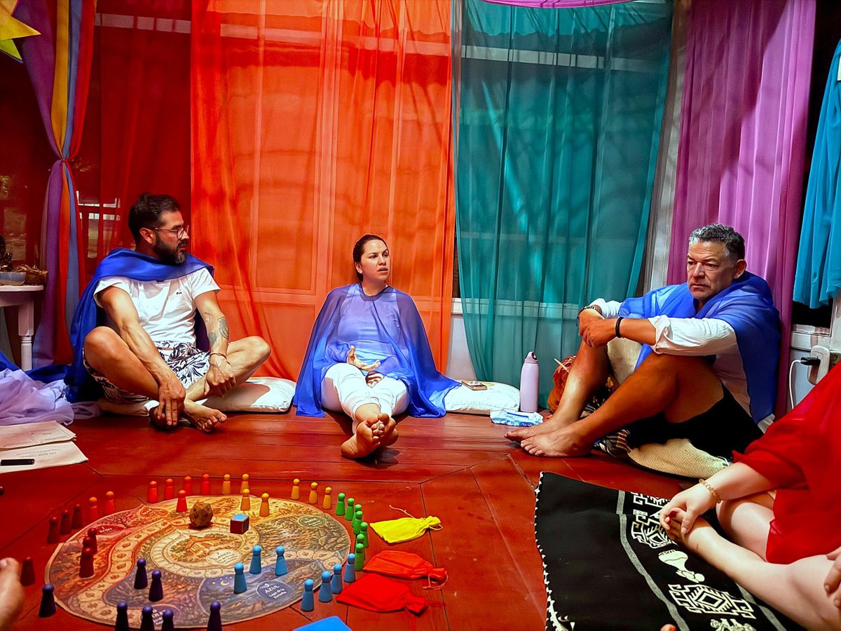 Three participants in blue veils sitting by the board