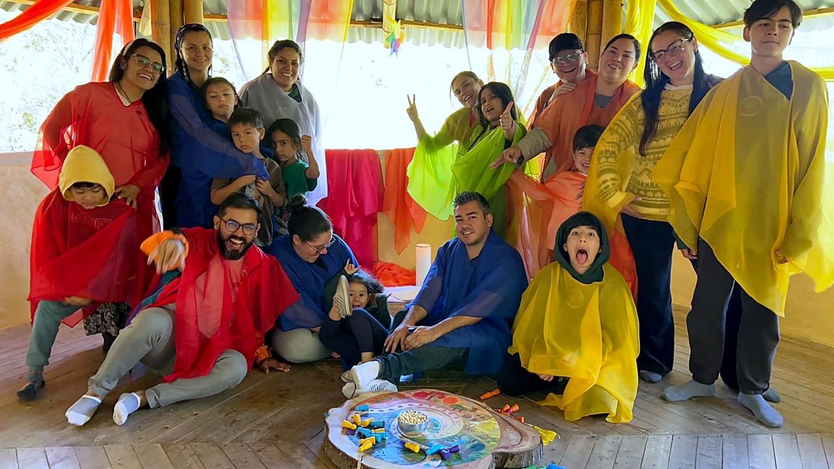 Families and kids in colored veils in a bamboo gazebo at the end of the gathering